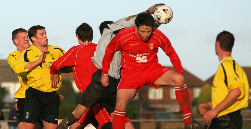 Jon Hendrick grabs the ball from between 2 Redhill players
