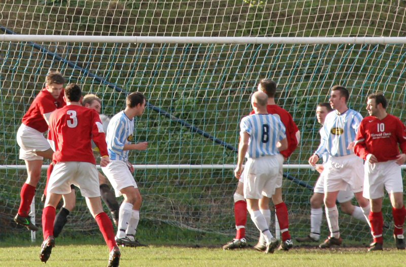 Dean Fuller in the Worthing United goal holds the ball firm under pressure from Barry Pidgeon 
