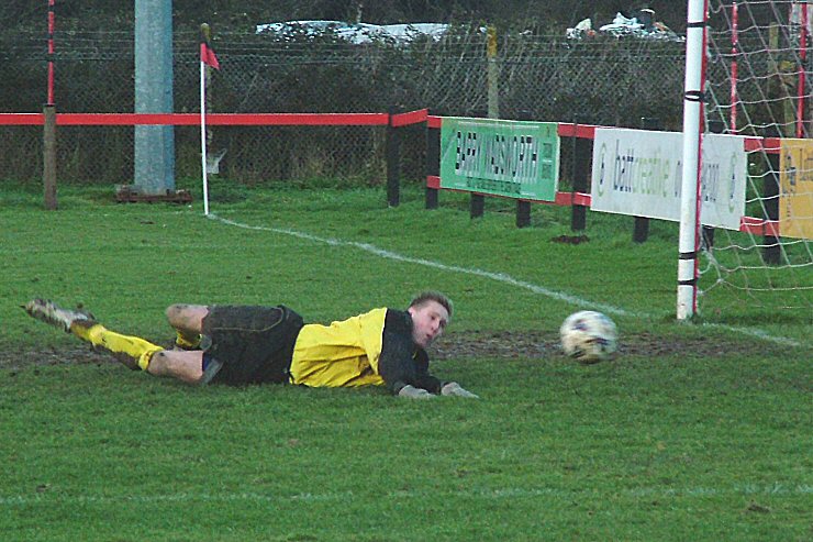 Adam Laundon in the Shoreham goal turns this shot round the post
