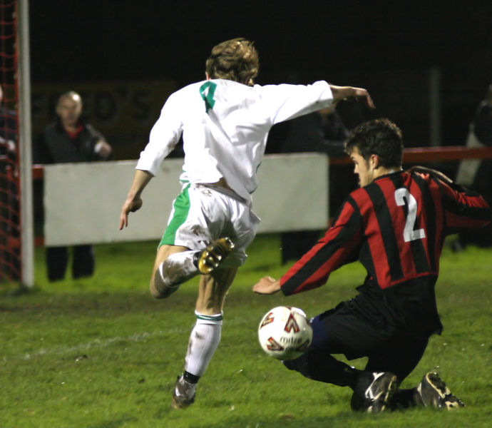 Mark Dixon (2) stops a run on goal by Ben Hitchman (4) ...
