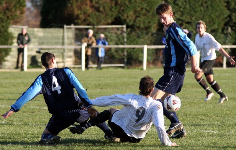 Phil Elkins and Kevin Budge go for the ball with Ryan Macmillan (?) close by 
