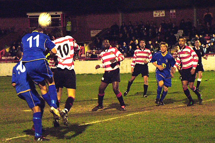 Michael Woolner (11) beats Martyn Lee (10) to head across the box
