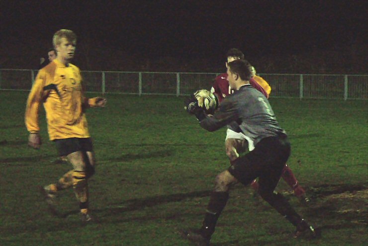 Tom Graves watches Horsham keeper Gary  Elliott gather the ball under pressure from Jason Wimbleton. 
