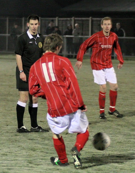 Mike Huckett plays the ball to Simon Clayton watched by referee Tim Robinson
