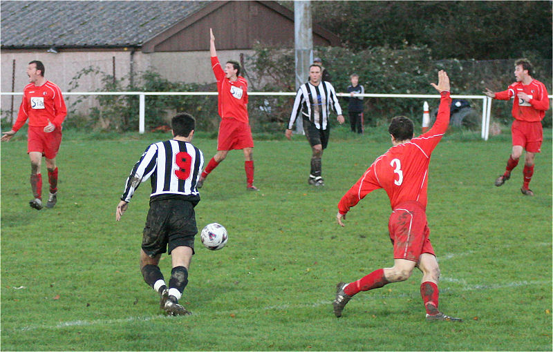 Phil Gault (9) about to blast the ball home for his hat trick as Steyning players appeal for handball
