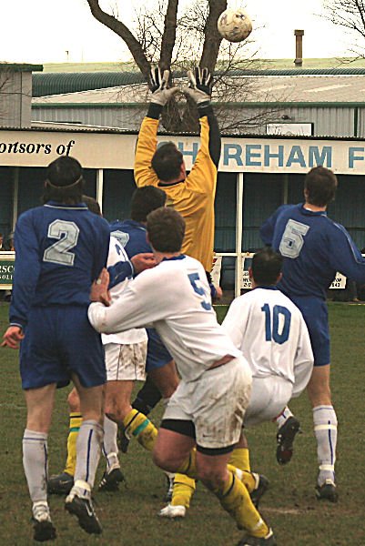 Darren Lambert reaches for the ball under pressure from three Shoreham players
