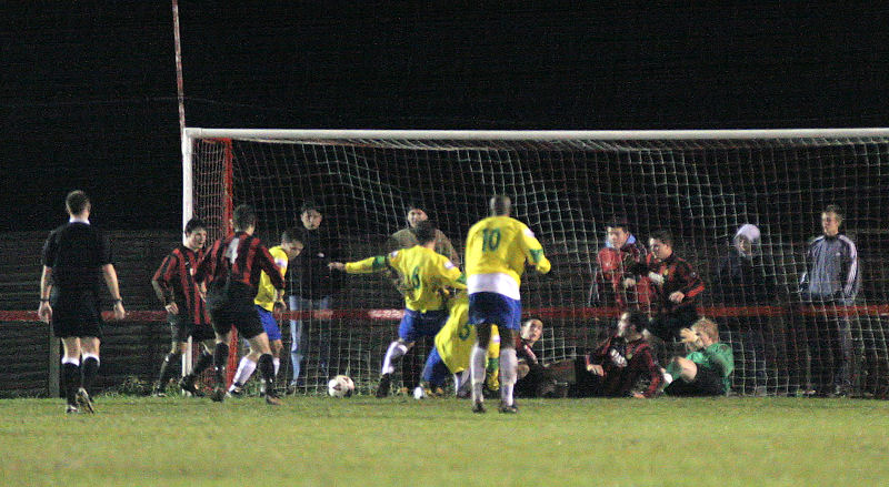 Ryan Bradley (yellow - left) scrambles home the Lewes winner on 82 minutes

