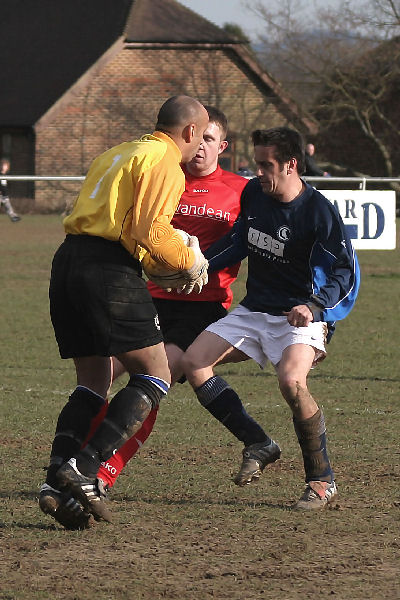 Keeper Kush Movaffagh grabs the ball in front of Danny Curd and Darren Clifton
