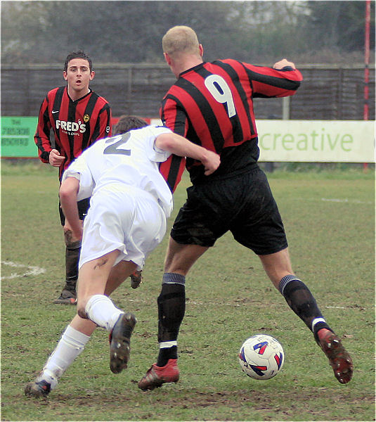 Kane Evans (9) shields the ball from Lewis Parsons (2) with Marc Cooper on hand
