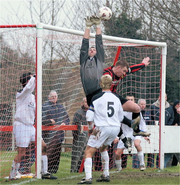 Keeper Mark Oldroyd just gets a touch on the ball before Danny Curd gets there ...
