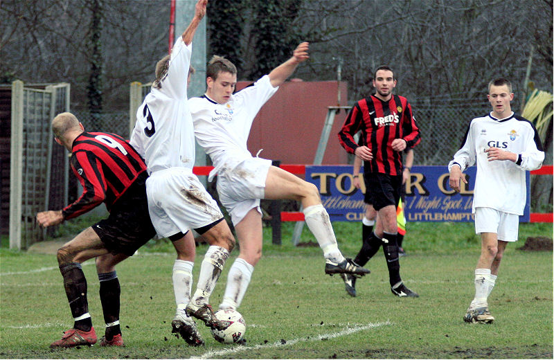 Eastbourne Utd defenders scamble the ball away from Kane Evans (9)
