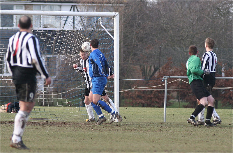 The keeper is beaten but Simon Bailey (?) heads clear
