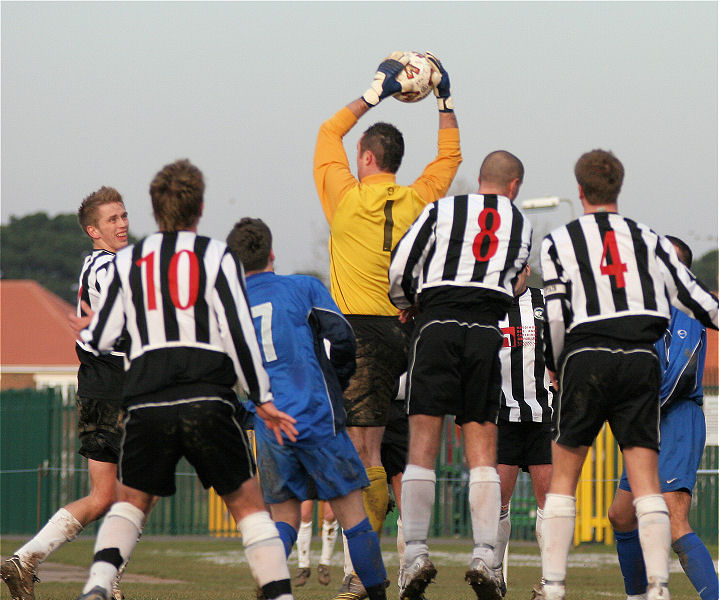 Andy McCarthy collects surrounded by Peacehaven players
