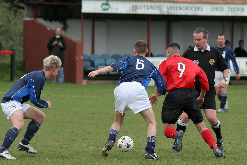 The ref watches very closely as Danny Baker (6) and Hassan Yassan (9) fight for the ball

