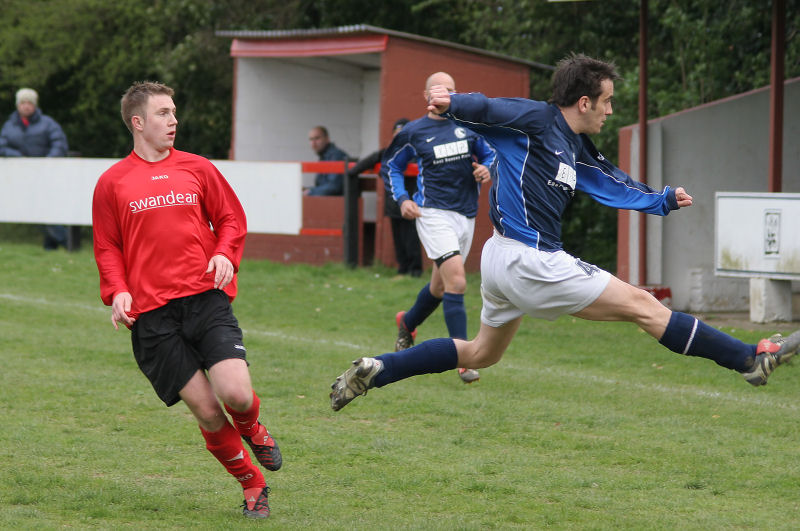 Darren Clifton races across to belt the ball away from Danny Curd
