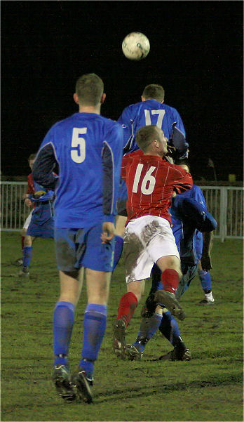 Subs Dan Swain (17) and Danny Cooper (16) go up for a header watched by Chris Hazell (5)
