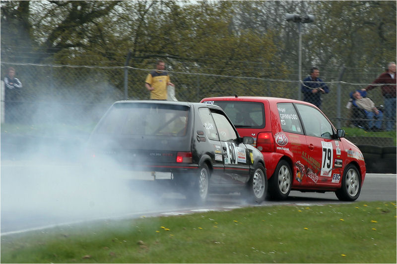 Nick Clark in the black Peugeot 205 GTi brakes hard as Nigel Grimwood in the red VW Lupo takes the inside line at Druid's
