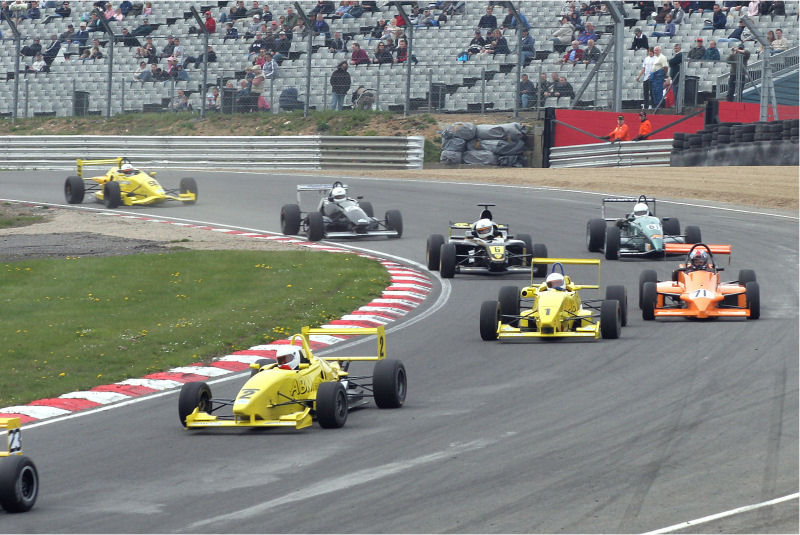 The Formula 4 cars of Barry Pritchard (2), Adrian Kidd (1), Andy Woolley (71), David Longstaff (6), Chris Kite (61) and Chris Milner (27) drop down through paddock 
