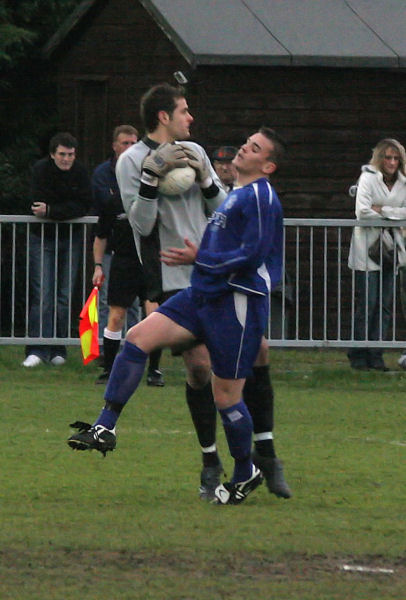 Bosham keeper Byron Kearns grabs the ball challenged by Craig Cox
