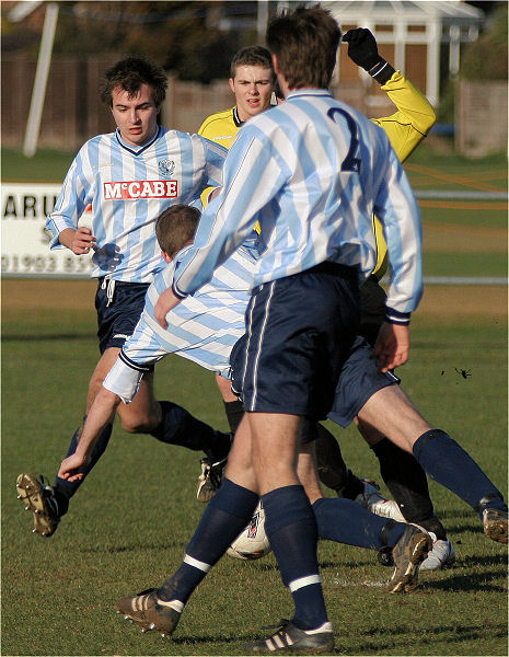 Derek Chester takes on several Worthing United players
