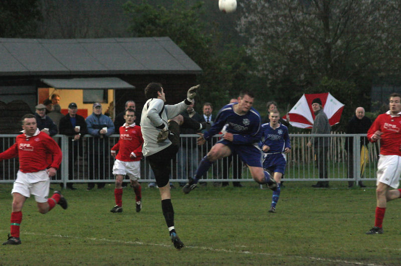 Byron Kearns whacks the ball away as Craig Cox steams in
