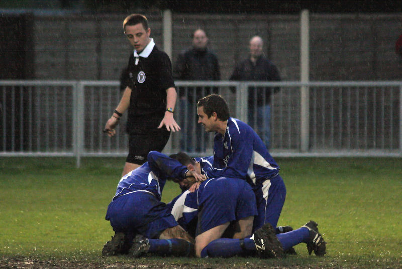 ... and the Rustington players pile in to congratulate him
