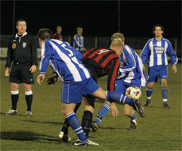 Kane Evans (9) goes between Danny Wackett (5) and Gary Bidwell
