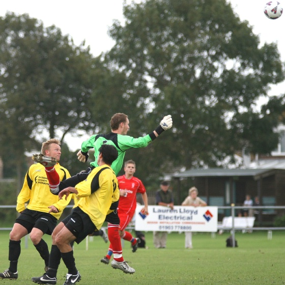 Keeper Dan Kelton races out to head clear
