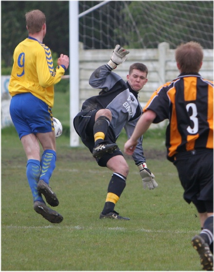 Three Bridges keeper Mark Fox blocks this effort by Mike O'Neill
