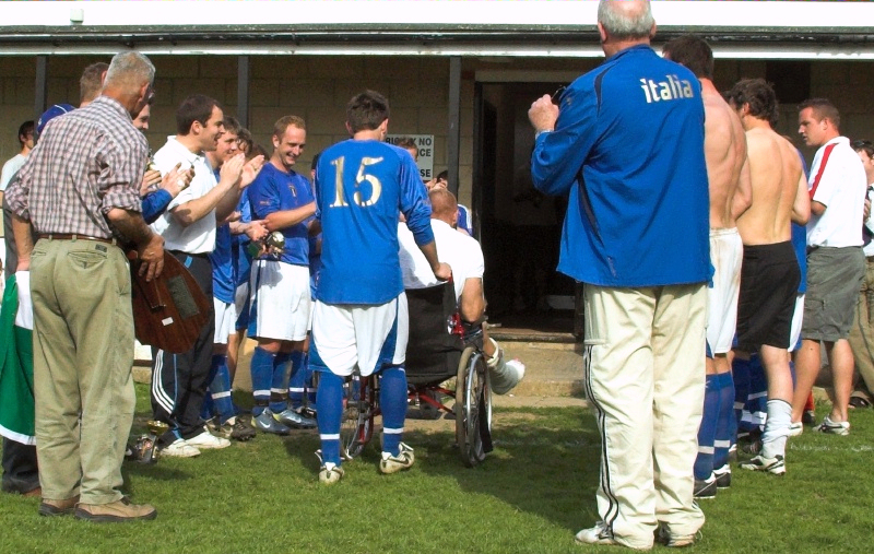 Wayne Laycock, who broke his foot in last week's game leaves the pitch applauded by the team
