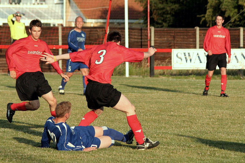 Wick's Tom Bird and Rustington's James Highton challenge for the ball watched by Carl Twine
