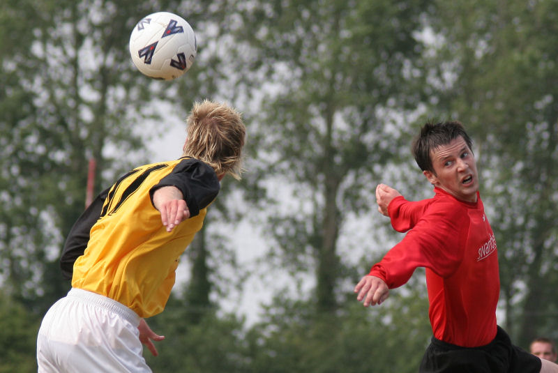 Peter Featherstone goes for a header with John Spragg
