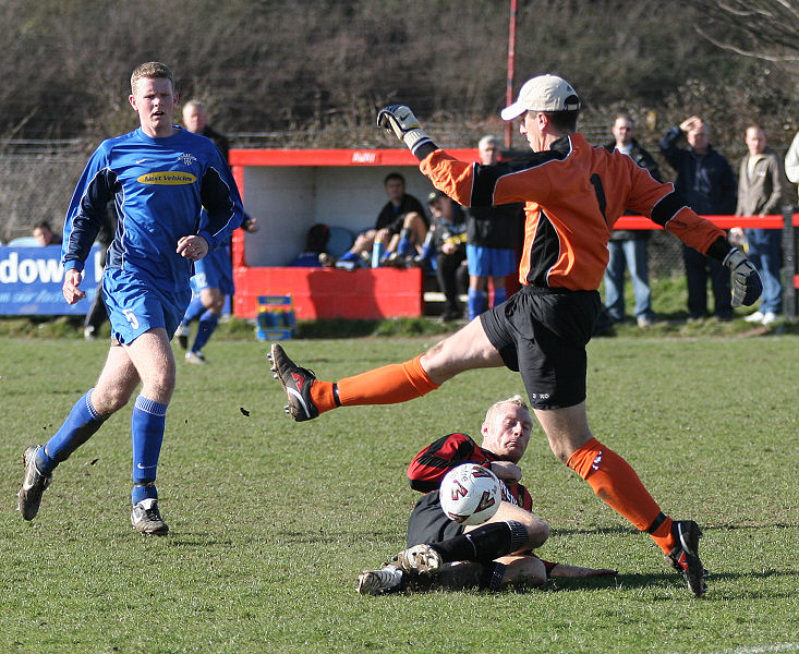 Simon Davey tries to hack the ball away from Kane Evans
