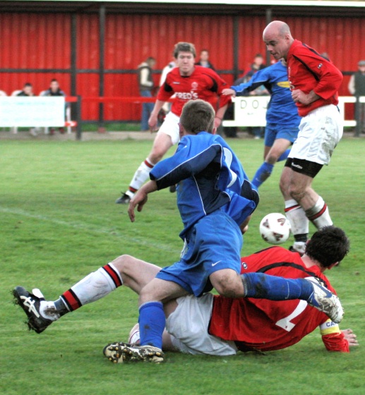 Dave Sharman gets the ball away from Jason Winch and Tony Miles puts it out for a corner
