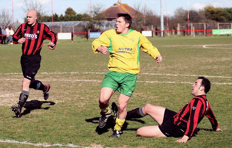 Peter Cooper, tackled by Pete Christodoulou, watches his effort go over the bar
