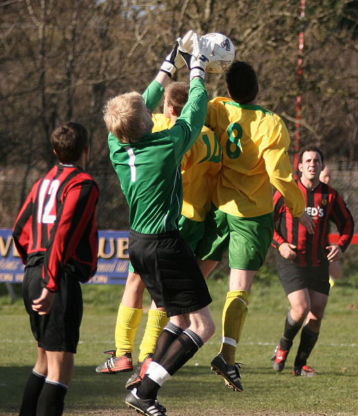 Tom Rand knocks the ball away from the heads of Martin Richardson and Steve Stracey
