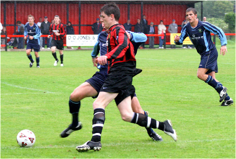 Adam Burton is challenged by Julian Curnow on a late run into the area
