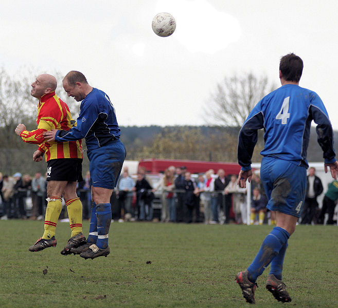 Jason Spiteri and Richie Hellen compete for a header watched by Brett Neal
