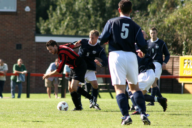 Ollie Howcroft gets the ball away from Mike Huckett watched by Stuart Hack (5) and Dave Walker (9)
