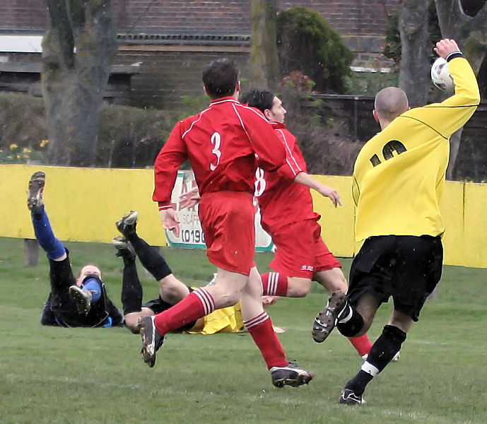 Stephen Gillett puts the ball out before James West can reach it
