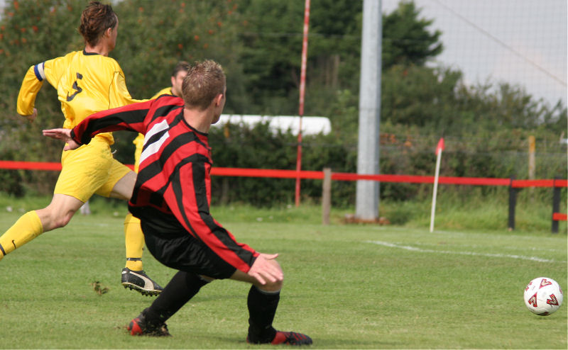 Danny Curd sends the ball towards an open goal ...
