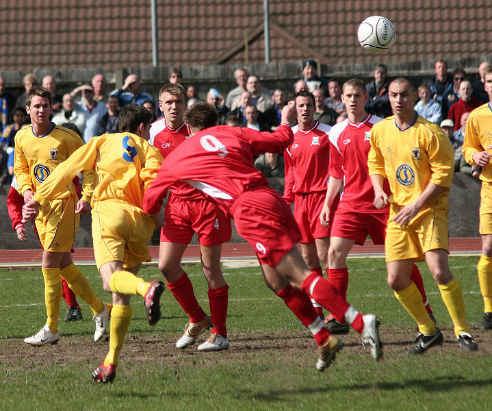 Paul Barnes (9 yellow) gets a powerful header ...
