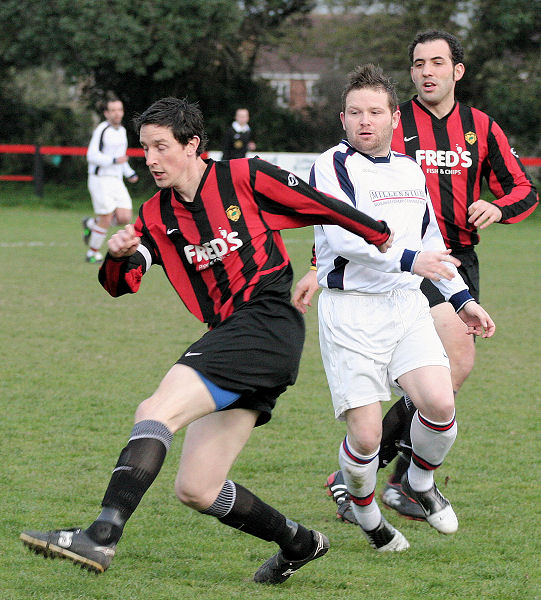 Dave Sharman clears the ball away from Jan Miller with Pete Christodoulou backing up
