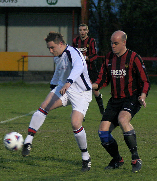 Sinon Corona controls the ball watched closely by Tony Miles
