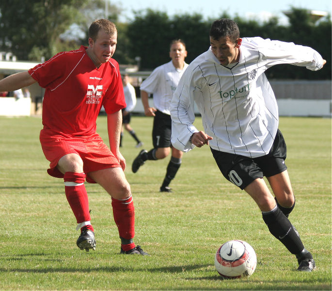 Phil Churchill on the ball is closely watched by Ollie West
