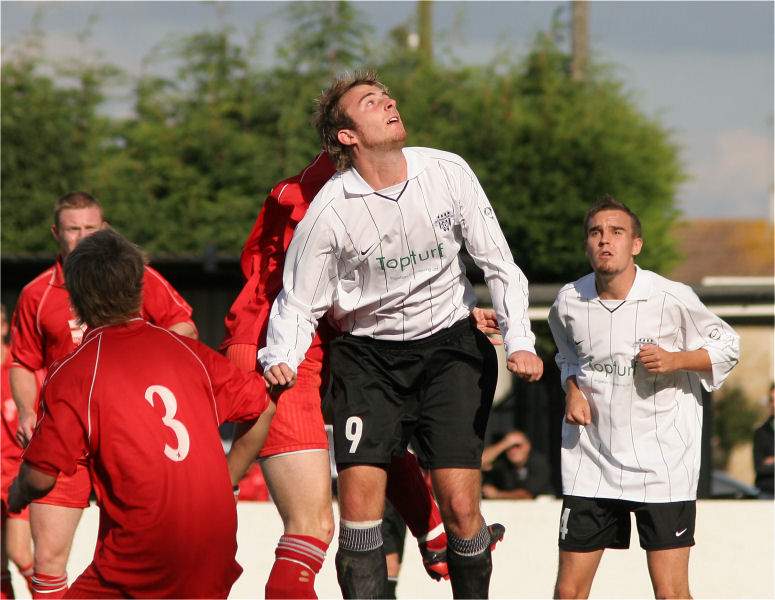 Josh Biggs (9) jumps for a header watched by Jamie Still (3) and Ryan Dick
