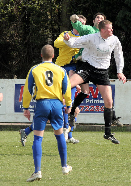 Greg Nessling punches the ball from the head of Chris Hazell
