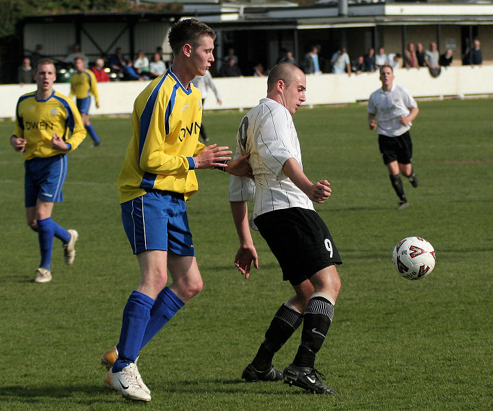 Josh Biggs controls the ball watched closely by Tom Rowe
