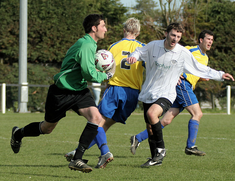 Greg Nessling grabs the ball ahead of Mark Windsor running in
