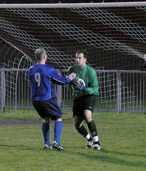 Ben O'Connor collects the ball in front of Darren Annis
